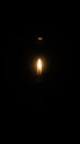 The flame of a candle shining in the darkness