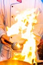 Flame cooking, Fire burn is cooking on iron pan, Chef in restaurant kitchen at stove with pan