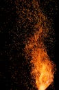 Flame of fire with flying burning red sparks on a black background. Fiery glowing particles flying away in night sky