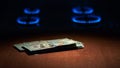 Flame of gas stove and hundred dollar Royalty Free Stock Photo