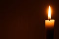 Flame of one white burning brightly wax  candle on the dark black background . Mourning candle. Isolated, close up. Lighting a can Royalty Free Stock Photo