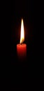 Flame red candle burns on a dark background