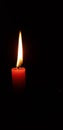 Flame red candle burns on a dark background