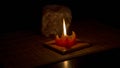 The flame of red candle illuminates the stone salt