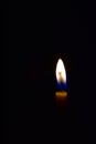 The flame of the yellow candle in the dark room Royalty Free Stock Photo