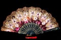 Flamenco hand fan with colorful pattern isolated on black background. Spanish or Chinese influence