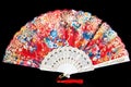 Flamenco hand fan with colorful pattern isolated on black background. Spanish or Chinese influence