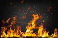 Flame with sparks in front of black background Royalty Free Stock Photo
