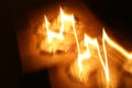 Flames of fire from a wax candle reflected in themselves in form an illustration of figure in boke
