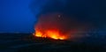 Flames of massive Forest Fire, aerial view at night. Nature wildfire in dry season. Burning trees and meadows Royalty Free Stock Photo