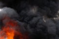 Flames of red fire and motion blur clouds of black smoke covered sky Royalty Free Stock Photo