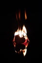 Flaming matches over candles with a red heart. Black background. Royalty Free Stock Photo