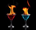 Flaming red and blue cocktails over black Royalty Free Stock Photo