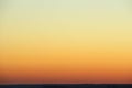 Flaming sky over the horizon during sunset or sunrise. Bright iridescent colors of yellow, orange and red. Colored background for