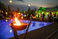 Flaming torch at sunset by the pool Royalty Free Stock Photo