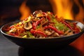 flaming wok with mushrooms and peppers, sizzling