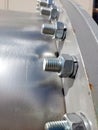 Detailed Close-Up of Flange With Bolts and Nuts in Industrial Setting Under Bright Sunlight Royalty Free Stock Photo