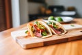 flank steak fajitas with grilled scallions on a wooden plate