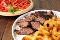 Flank steak with fries onion rings and salad Royalty Free Stock Photo