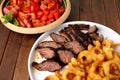 Flank steak with fries onion rings and salad Royalty Free Stock Photo