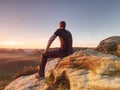 Flare. Man in sportswear is sitting on cliff`s edge Royalty Free Stock Photo