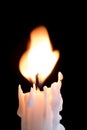 Flaring flame on top of a white candle Royalty Free Stock Photo