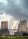 Flash bolt of lightning striking electric power station with cooling tower steam chimneys in storm with dramatic stormy clouds Royalty Free Stock Photo