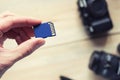 Flash card in hand on camera background, memory card for DSLR camera, flash drive, photo storage Royalty Free Stock Photo