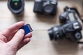 flash card in hand on camera background, memory card for SLR camera, flash drive, photo Royalty Free Stock Photo