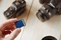 flash card in hand on camera background, memory card for SLR camera, flash drive, photo storage Royalty Free Stock Photo