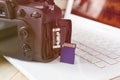 flash card in hand on camera and laptop background, memory card for SLR camera, flash drive, photo storage Royalty Free Stock Photo