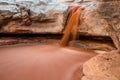 Flash flood muddy red water spilling over cliff in southern Utah Royalty Free Stock Photo