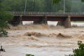 flash flood roars past bridge, with water levels rising and threatening to topple the structure