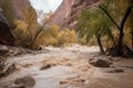 flash flood rushes through deep and winding canyon, with trees and rocks washed downstream Royalty Free Stock Photo
