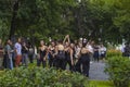 Seven Women dancers in black leather bodysuits and black body-hugging trousers dance outdoors