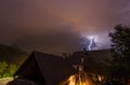 Flash during a thunderstorm at night behind a farming house