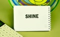 A flashcard displaying the word shine rests beside a calculator on a vibrant surface, highlighting an engaging study