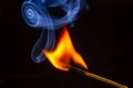 Flashed and burning wooden match on a dark background close-up. Bright fire and smoke from a burning tree Royalty Free Stock Photo