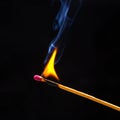 Flashed and burning wooden match on a dark background close-up. Bright fire and smoke from a burning tree Royalty Free Stock Photo