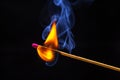 Flashed and burning wooden match on a dark background close-up. Bright fire and smoke from a burning tree Royalty Free Stock Photo