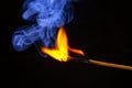 Flashed and burning wooden match on a dark background close-up. Bright fire and smoke from a burning tree Royalty Free Stock Photo