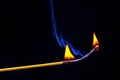 Flashed and burning wooden match on a dark background close-up. Bright fire and smoke from a burning tree Royalty Free Stock Photo