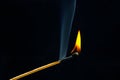 Flashed and burning wooden match on a dark background close-up. Bright fire and smoke from a burning tree Royalty Free Stock Photo