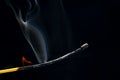 Flashed and burning wooden match on a dark background close-up. Bright fire and smoke from a burning tree Royalty Free Stock Photo