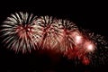 Flashes of red and white fireworks against black sky Royalty Free Stock Photo