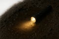 A flashlight illuminating a muddy puddle in the ground. Space for text. Royalty Free Stock Photo