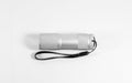 White aluminum LED flashlight with black strap isolated on whit