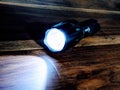 Flashlight light in the dark on wooden background. Torchlight.