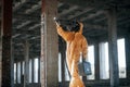 With flashlight. Man dressed in chemical protection suit in the ruins of the post apocalyptic building