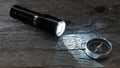 Flashlight and ray of light, compass on wooden background Royalty Free Stock Photo